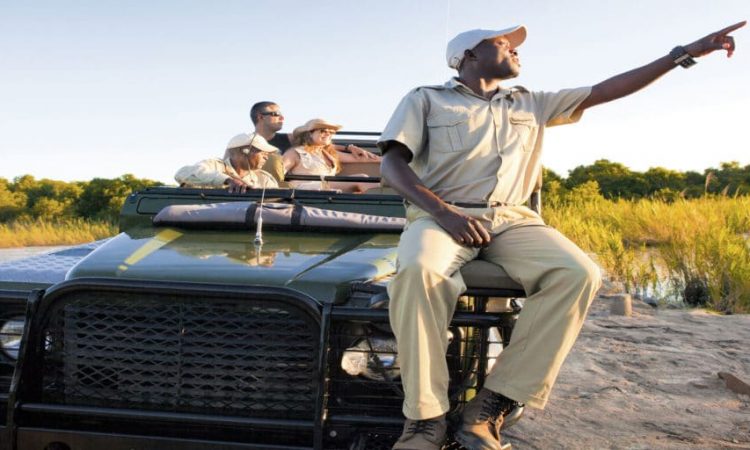 FAQ's, tourist asking guide Uganda, gorilla permit FAQs, Uganda travel questions, Siyabonge team helping traveler, Uganda safari briefing photo